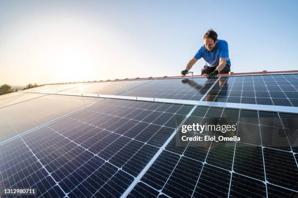professionelle arbeiter installation sonnenkollektoren auf dem dach eines hauses. - solar panel home stock-fotos und bilder