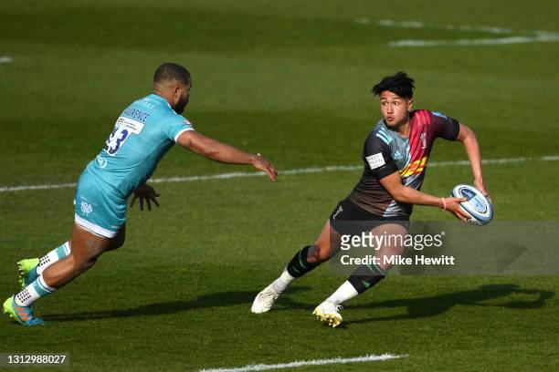 Marcus Smith of Harlequins passes the ball under pressure from Ollie Lawrence of Worcester Warriors during the Gallagher Premiership Rugby match...