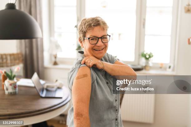 mujer mayor feliz de ser vacunada - esparadrapo fotografías e imágenes de stock