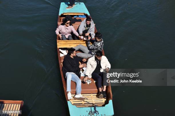 Group of friends enjoy a drink while riding on a punt on the River Cam on the first weekend since the easing of lockdown restrictions on April 17,...