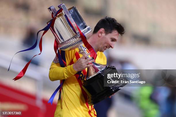 Lionel Messi of FC Barcelona walks off with the trophy after winning the Copa Del Rey Final match between Athletic Club and Barcelona at Estadio de...