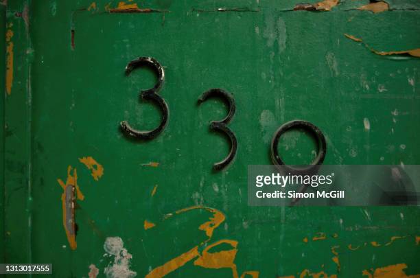 number 339 street address in raised metal numerals on dark green metal door - house number stock pictures, royalty-free photos & images