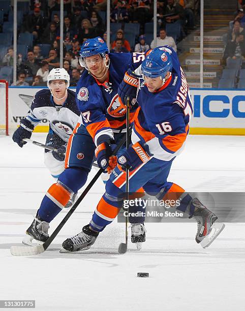 Blake Comeau of the New York Islanders collides with teammate Marty Reasoner while in pursuit of a loose puck at Nassau Veterans Memorial Coliseum on...