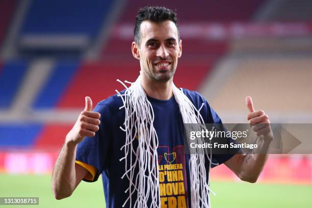 Sergio Busquets of FC Barcelona poses for a photograph with a piece of the goal net following his team's victory in the Copa del Rey Final match...