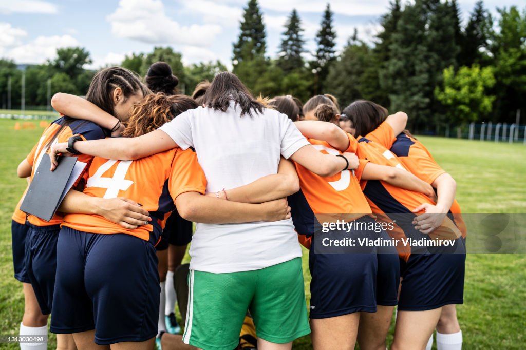 女子足球隊和教練擁抱