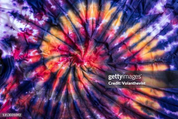 bright and colorful tie dye swirl pattern on cotton clothes - traditioneller batikstil stock-fotos und bilder