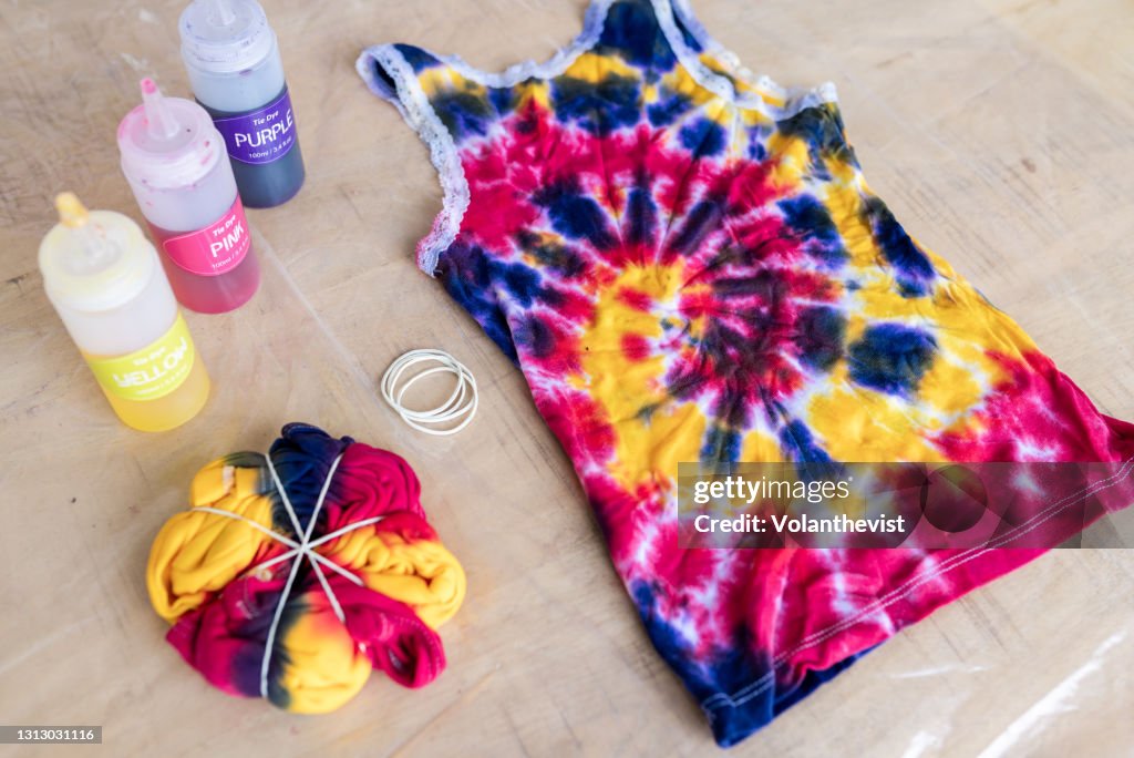 Dosing containers with colored ink and tie dye clothes on plastic protector