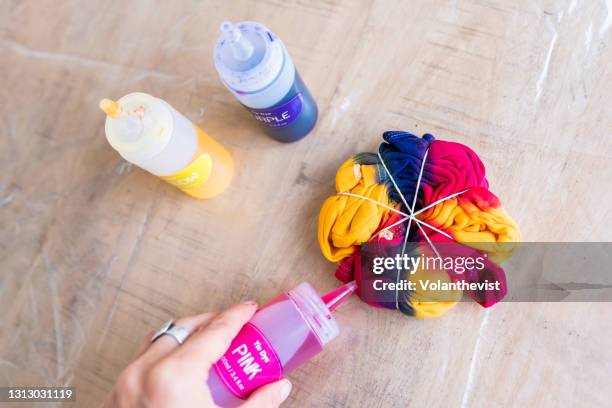 making tie dye clothes at home on pink, yelow and purple for summer - abbindebatik stock-fotos und bilder