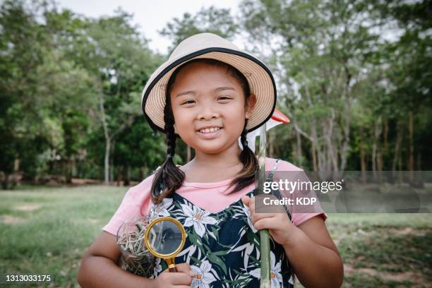 portrait of a little girl with catching butterflies equipment at the back yard garden. science and education exploration photography themes - catching bugs stock pictures, royalty-free photos & images