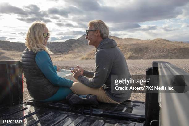 couple look at map and phone on rear tailgate of vehicle - fruita colorado stock pictures, royalty-free photos & images