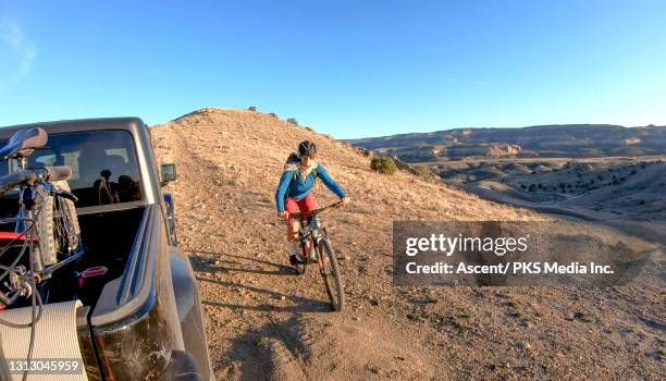 mountain biker arrives at parked vehicle, desert landscape - glen haven co stock pictures, royalty-free photos & images