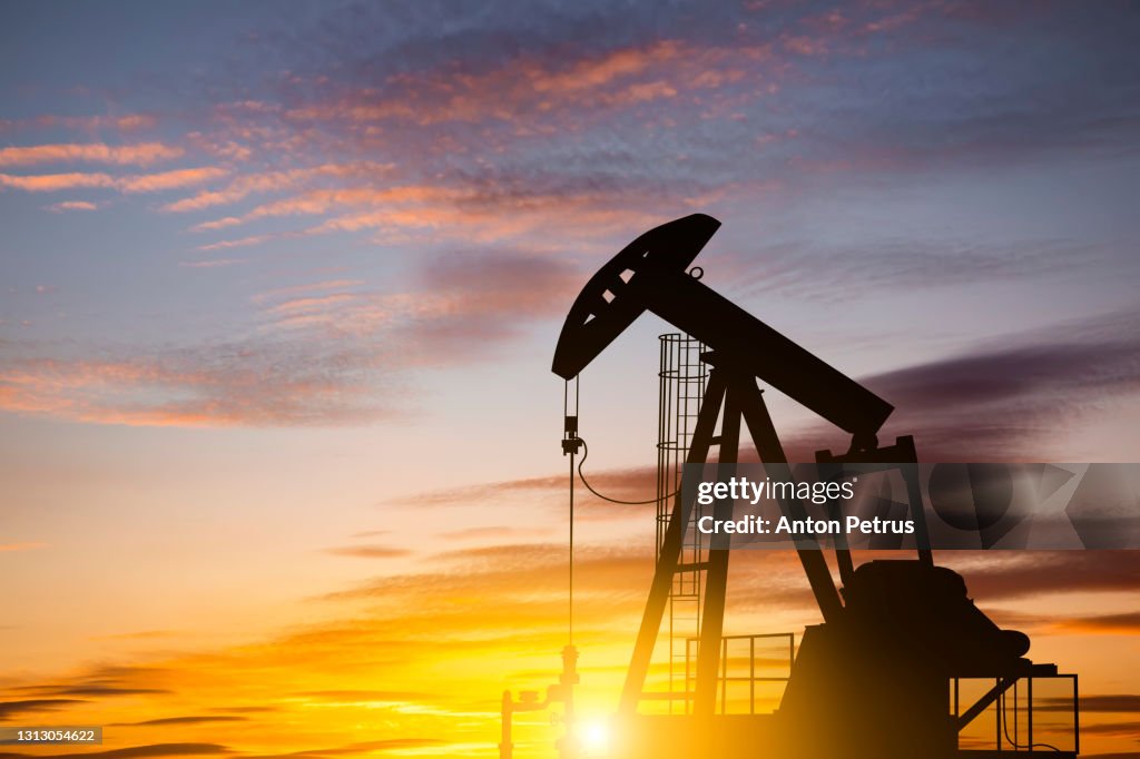 Oil pump on a sunset background. World Oil Industry