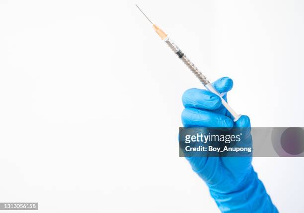 close up of doctor/nurse hand holding a syringe needle, ready for injection medicine to patient. - needle plant part stock pictures, royalty-free photos & images