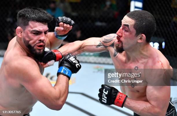 Robert Whittaker of Australia punches Kelvin Gastelum in a middleweight fight during the UFC Fight Night event at UFC APEX on April 17, 2021 in Las...