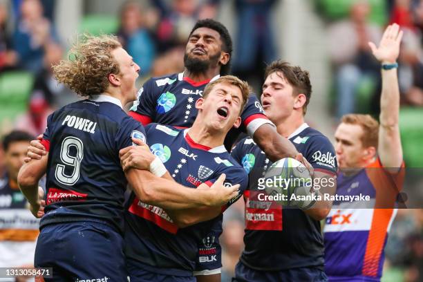 Joe Powell celebrates with Tom Pincus and Frank Lomani after Powell of the Rebels scores a try during the round nine Super Rugby AU match between the...