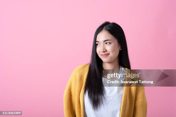 young beautiful woman wearing casual shirt over isolated pink background looking away to side with smile on face, natural expression. laughing confident. - woman smile stockfoto's en -beelden