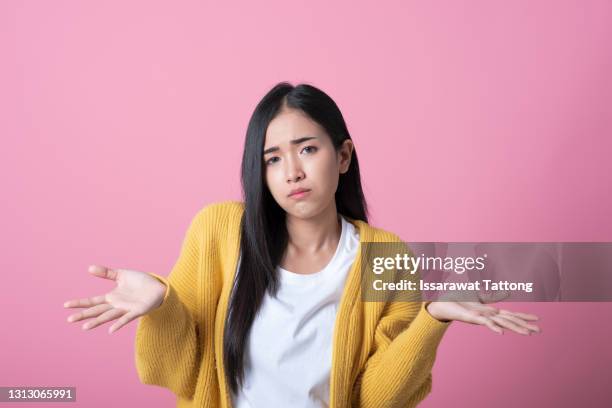 portrait of beautiful woman who do not understand what is happening. isolated pink background. - portrait young adult caucasian isolated stockfoto's en -beelden