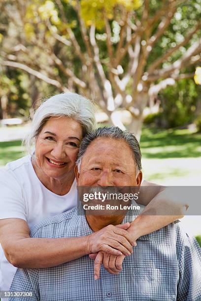 Senior hispanic woman hugging husband, portrait