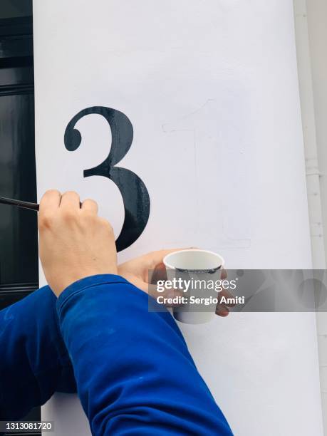 hand painting a house number - house number stock pictures, royalty-free photos & images