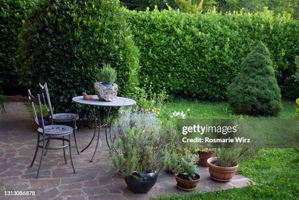 back garden with table, flower pots with kitchen herbs - garden feature stock pictures, royalty-free photos & images