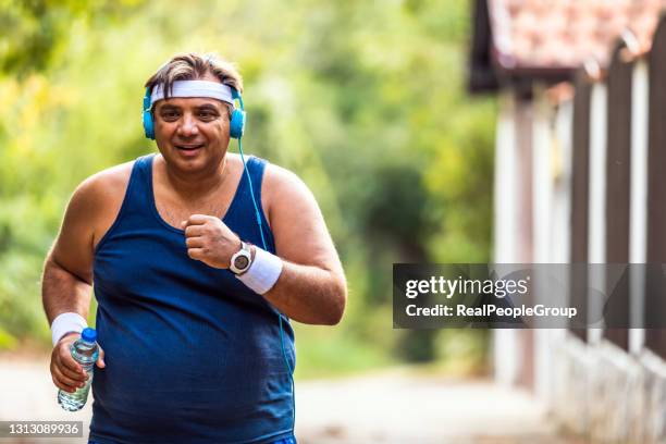 mature overweight man running outdoors. fitness lifestyle - fat loss training stock pictures, royalty-free photos & images