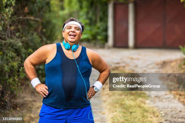 overweight man slowly running outdoors, active lifestyle as struggle with obesity - fat loss training stock pictures, royalty-free photos & images