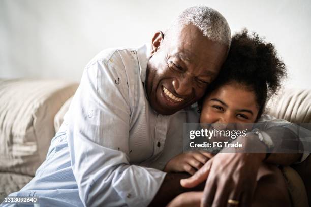 自宅で孫娘を抱きしめる祖父の肖像画 - thankful man ストックフォトと画像