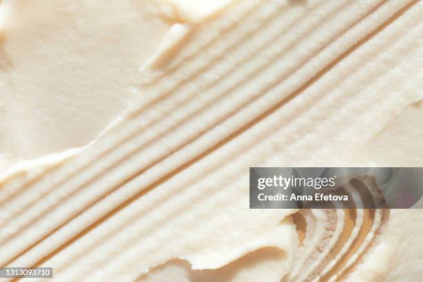 appetizing textured brush strokes of vanilla ice cream or lemon sorbet on beige background. flat lay style - crèmekleurig stockfoto's en -beelden