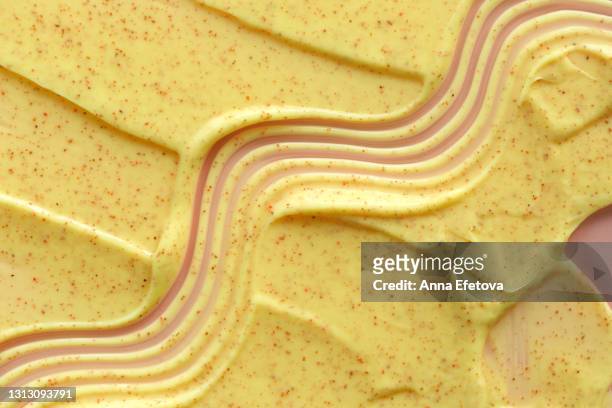 textured smears of yellow yogurt on pastel pink background. flat lay style and close-up - yellow smoothie stock pictures, royalty-free photos & images