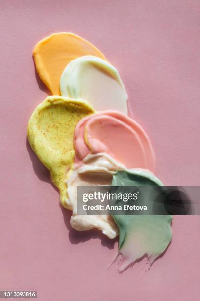 set of many smears of yogurt, melted ice cream and sorbets on pastel pink background. flat lay style - fumigation photos et images de collection