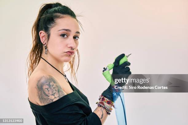 woman holding tattoo machine - tattoo needle stock pictures, royalty-free photos & images