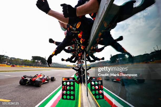 Race winner Max Verstappen of the Netherlands driving the Red Bull Racing RB16B Honda passes his team celebrating on the pitwall during the F1 Grand...