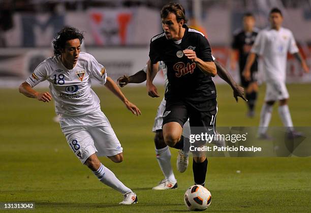 Fernando Hidalgo of Liga Deportiva Universitaria struggles for the ball with Luciano Civelli of Libertad during a match as part of Bridgestone...