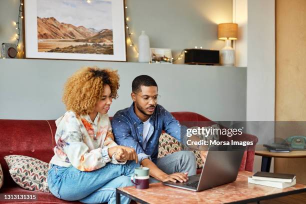 man talking with girlfriend while using laptop - couple pointing stock pictures, royalty-free photos & images