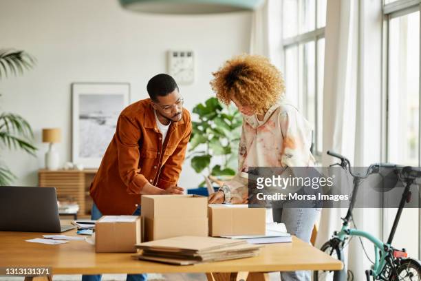 entrepreneurs analyzing packaging at table - small business stock pictures, royalty-free photos & images
