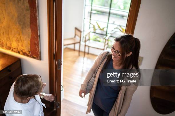 home caregiver talking to patient before living at her house - abrir a porta sair imagens e fotografias de stock