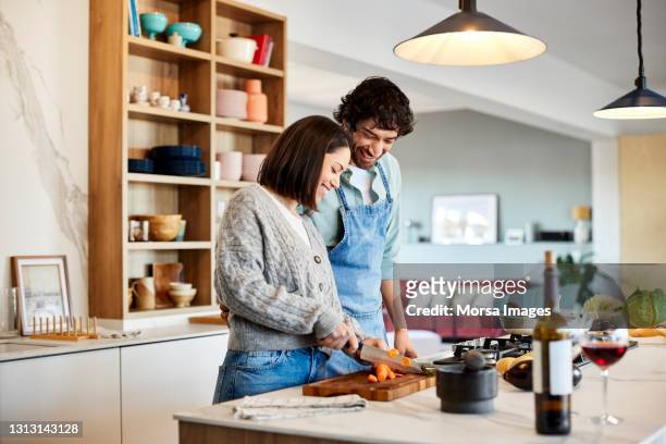 happy couple cooking food together at home - nur erwachsene stock-fotos und bilder