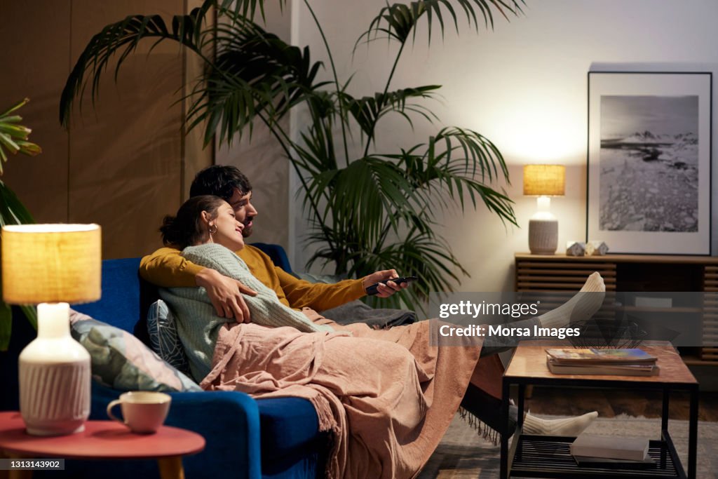 Mid Adult Couple Watching TV In Living Room