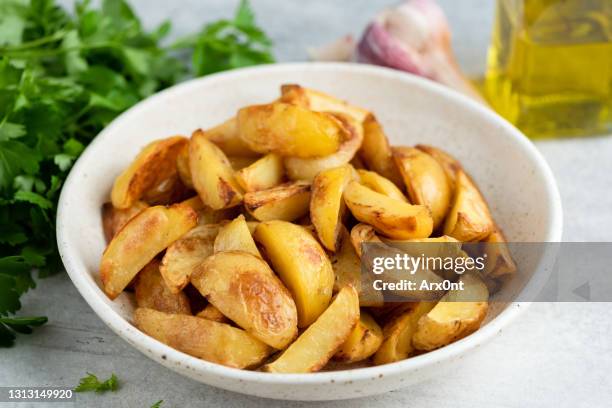 golden baked potato wedges - gepofte-aardappel stockfoto's en -beelden