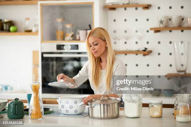 giovane donna che prepara cibo in cucina. immagine - bollente foto e immagini stock