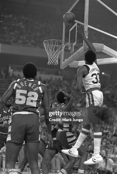 Denver Nuggets forward David Thompson shoots a short jumper over Cleveland Cavaliers guards Campy Russell and Austin Carr during an NBA basketball...