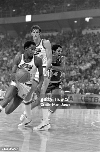Denver Nuggets forward David Thompson dribbles past a screen set by Bobby Jones on Cleveland Cavaliers guard Austin Carr during an NBA basketball...