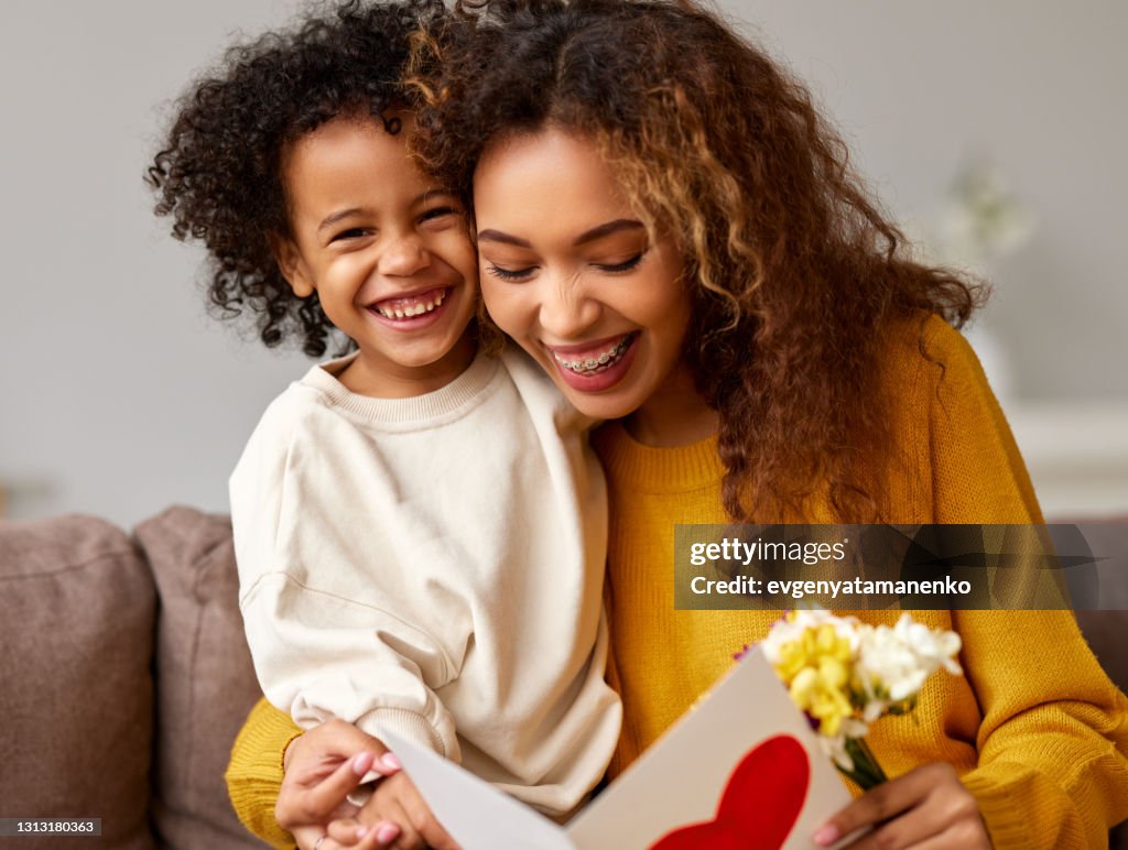 Young mixed race woman getting congratulations from son on Mothe