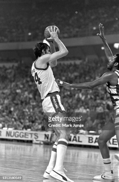 Denver Nuggets forward Bobby Jones attempts a pass over Cleveland Cavaliers forward Campy Russell during an NBA basketball game at McNichols Arena on...