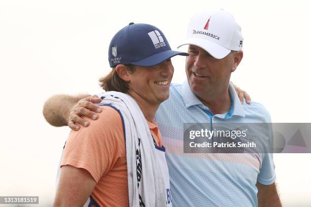 Stewart Cink of the United States celebrate with his caddie and son, Reagan Cink, on the 18th green after winning the RBC Heritage on April 18, 2021...