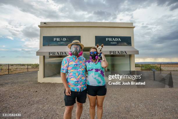 Vanlifers' Josh Brasted and Mary Alice Sandberg pose for a photo in respirators in front of the Prada Marfa sculpture by artists Elmgreen and Dragset...