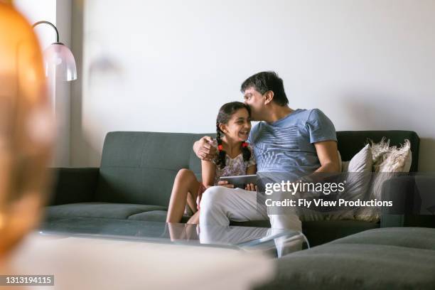 aanhankelijke vader en dochter die quality time samen thuis doorbrengen - australian family time stockfoto's en -beelden