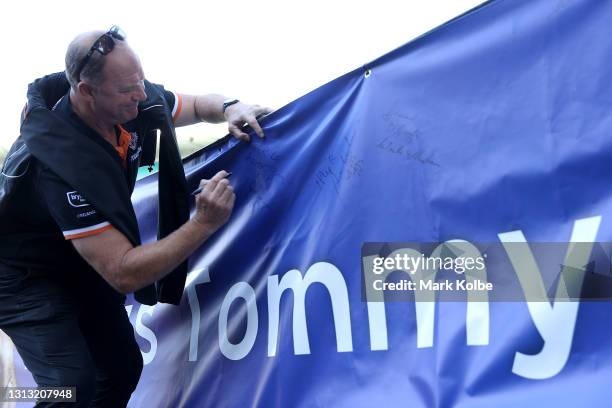 Former rugby league players Paul Sironen signs a message during the Tommy Raudonikis Memorial Service at the Sydney Cricket Ground on April 19, 2021...