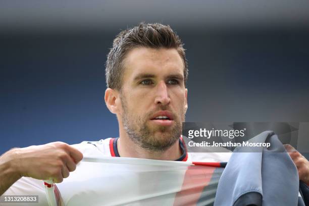 Kevin Strootman of Genoa CFC removes his match jersey to give to a ball boy following the final whistle of the Serie A match between AC Milan and...