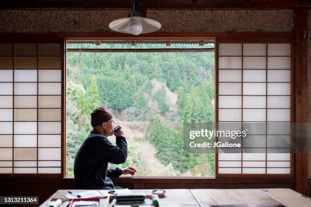 窓の外を見てお茶を飲む日本人�シニアアーティスト - 和室 ストックフォトと画像